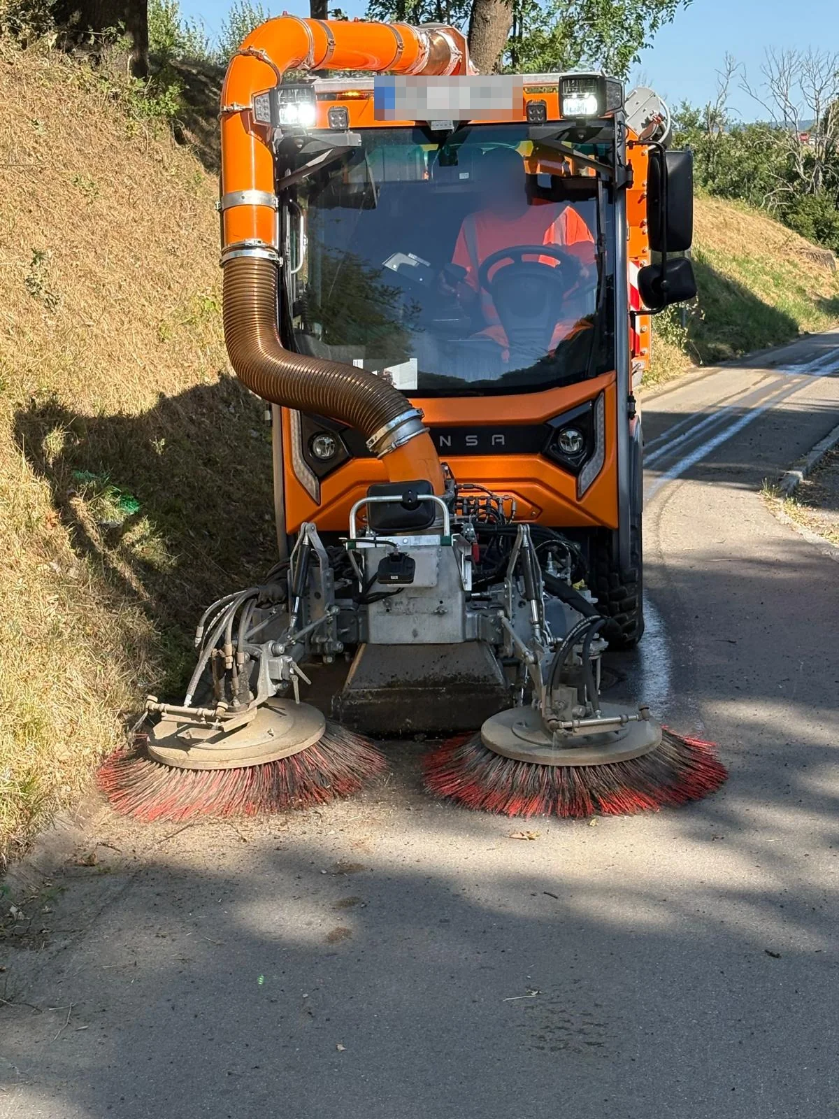 Hansa Kehrsaugmaschine mit Saugschlauch bei der Straßenreinigung an einer Böschung