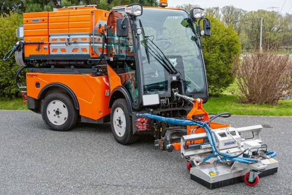 Orangefarbenes Kommunalfahrzeug mit Fiedler-Kehr- und Waschaufbau